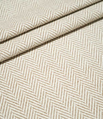 Layered folds of Bampton Taupe herringbone fabric, highlighting the repeating neutral chevron design, textured weave and fabric thickness.