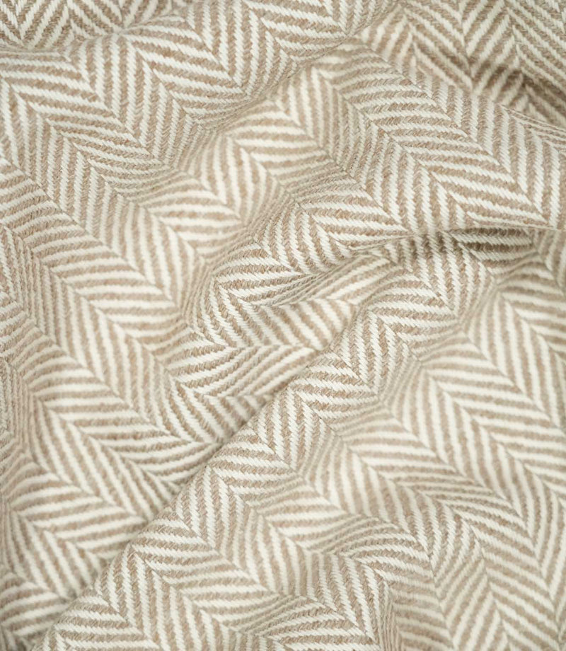 Bampton Taupe herringbone fabric loosely draped into soft folds, demonstrating its natural movement, warm neutral tones and defined woven pattern.
