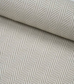 Rolled Bampton Argent upholstery fabric showcasing the woven herringbone chevron pattern in soft argent grey and ivory, ideal for curtains, blinds and upholstery projects.