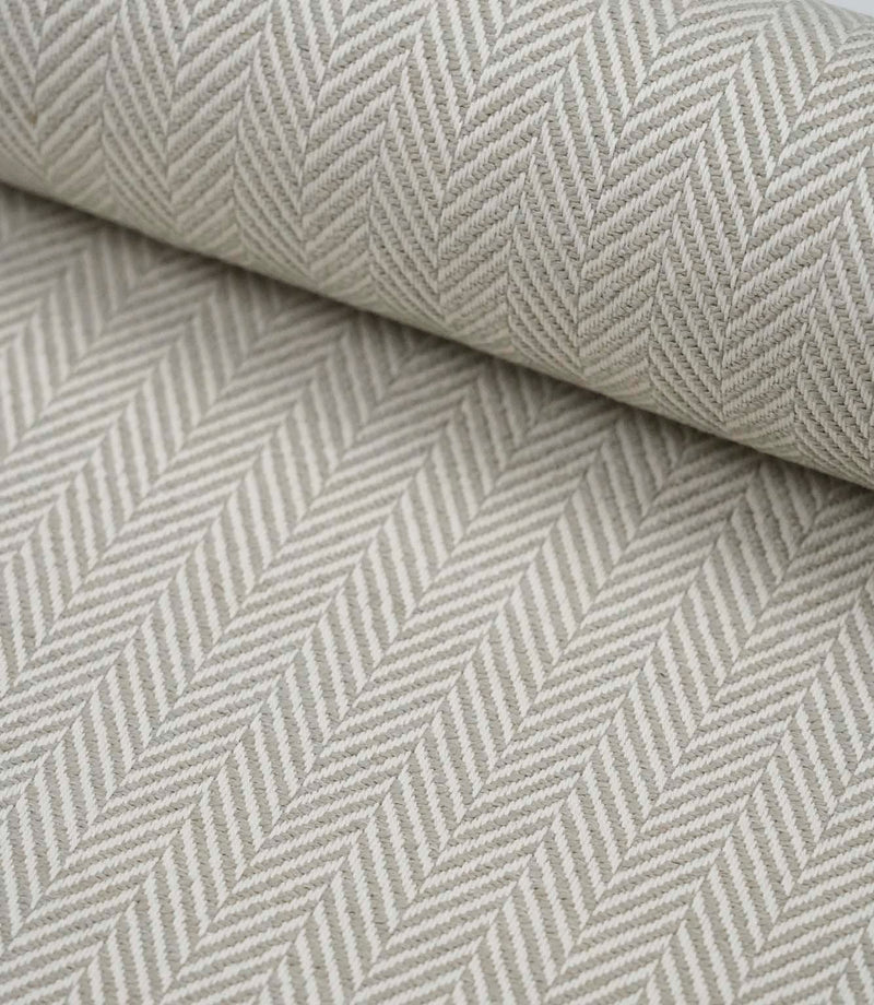 Rolled Bampton Argent upholstery fabric showcasing the woven herringbone chevron pattern in soft argent grey and ivory, ideal for curtains, blinds and upholstery projects.