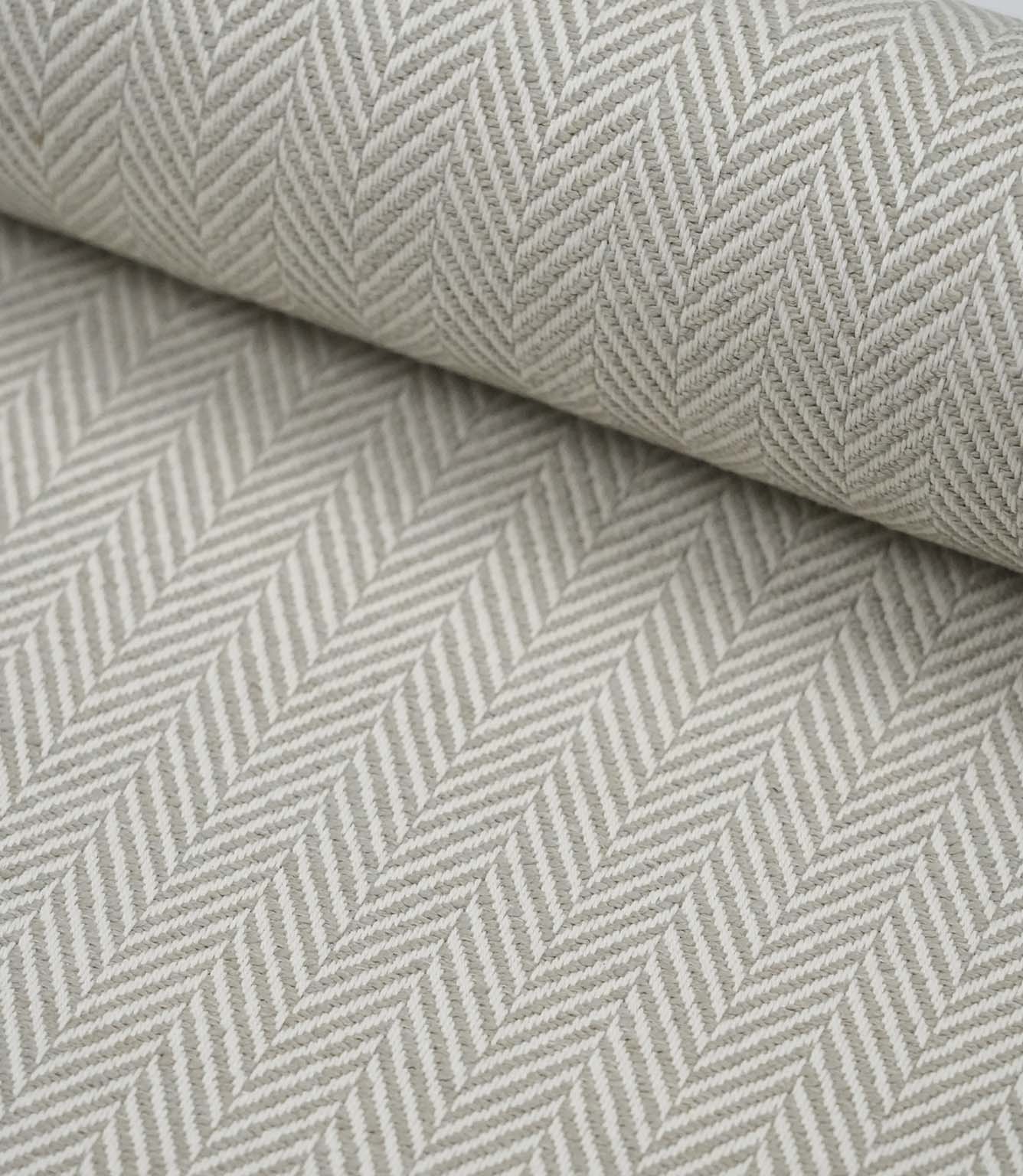 Rolled Bampton Argent upholstery fabric showcasing the woven herringbone chevron pattern in soft argent grey and ivory, ideal for curtains, blinds and upholstery projects.