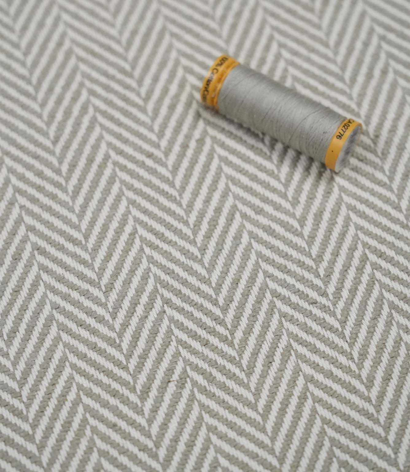 Bampton Argent woven herringbone upholstery fabric with matching grey sewing thread, highlighting the elegant chevron weave for upholstery and soft furnishing projects.