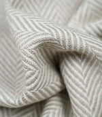 Macro close-up of Bampton Argent woven herringbone upholstery fabric highlighting the intricate chevron weave, soft texture and premium craftsmanship.