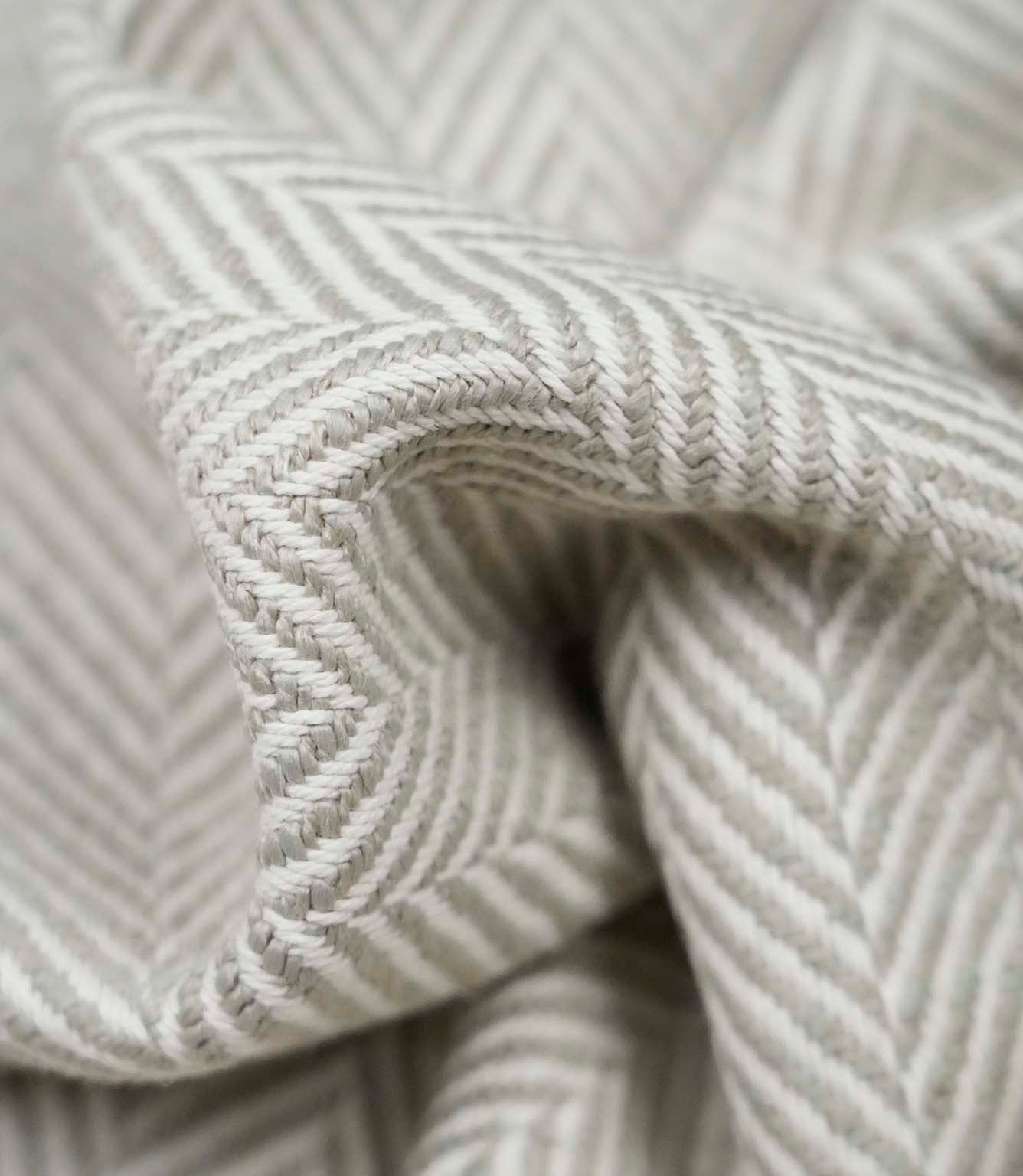 Macro close-up of Bampton Argent woven herringbone upholstery fabric highlighting the intricate chevron weave, soft texture and premium craftsmanship.