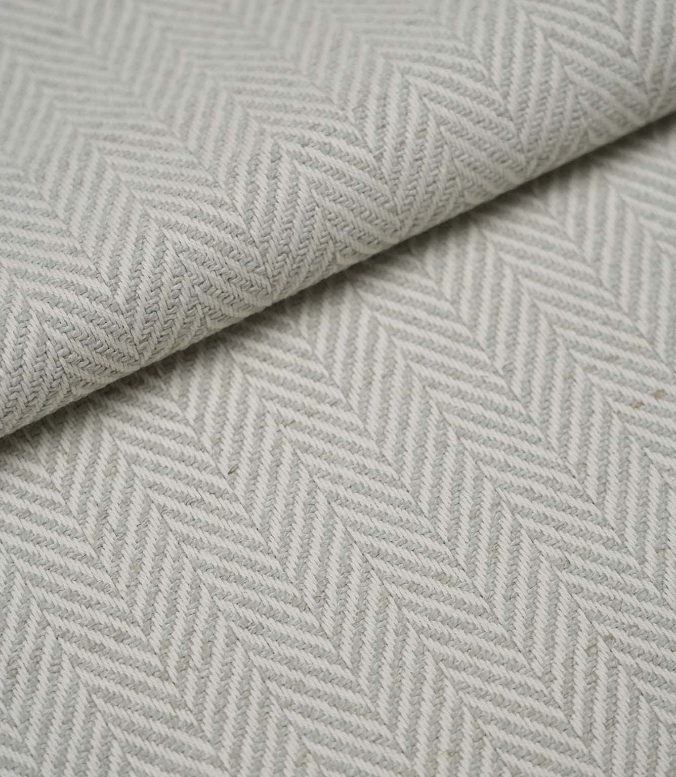 Folded Bampton Elephant Grey upholstery fabric displaying the woven herringbone chevron pattern and durable textured finish, ideal for curtains and upholstery.