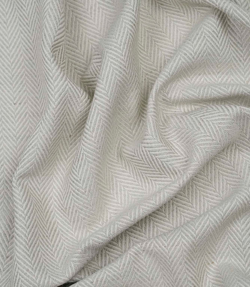 Draped Bampton Elephant Grey woven upholstery fabric highlighting its soft drape, textured herringbone weave and elegant elephant grey and ivory chevron pattern.