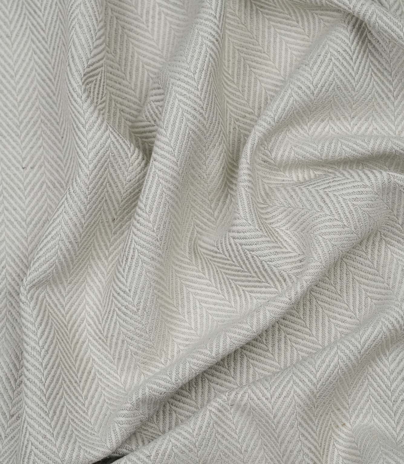 Draped Bampton Elephant Grey woven upholstery fabric highlighting its soft drape, textured herringbone weave and elegant elephant grey and ivory chevron pattern.
