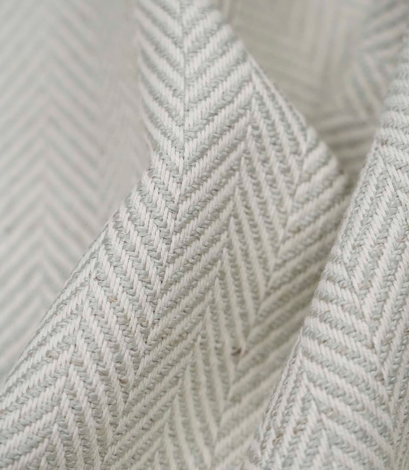 Macro close-up of Bampton Elephant Grey woven herringbone upholstery fabric showing the intricate chevron weave, textured finish and premium craftsmanship.