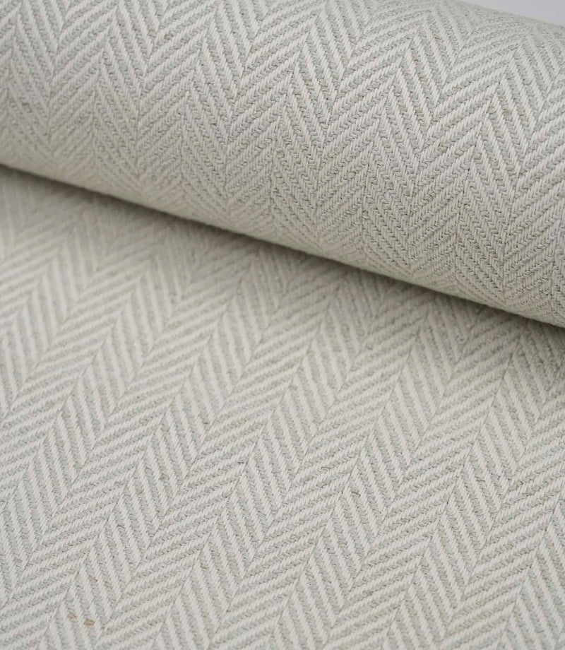 Rolled Bampton Elephant Grey upholstery fabric featuring a woven herringbone chevron pattern in elephant grey and ivory, ideal for curtains, blinds and upholstery projects.