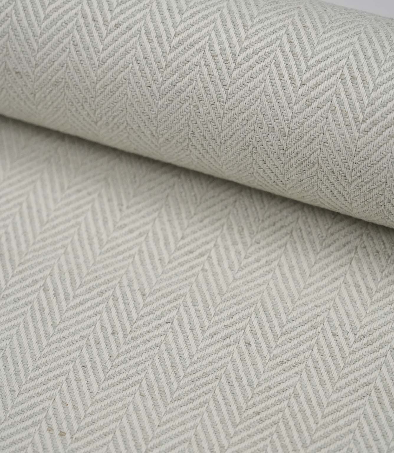 Rolled Bampton Elephant Grey upholstery fabric featuring a woven herringbone chevron pattern in elephant grey and ivory, ideal for curtains, blinds and upholstery projects.