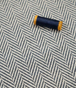 Bampton Ink woven herringbone upholstery fabric with matching navy sewing thread, highlighting the textured chevron weave for upholstery and soft furnishing projects.