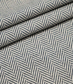 Layered Bampton Ink woven fabric featuring a bold chevron herringbone design in ink blue and ivory, ideal for premium upholstery and home décor projects.