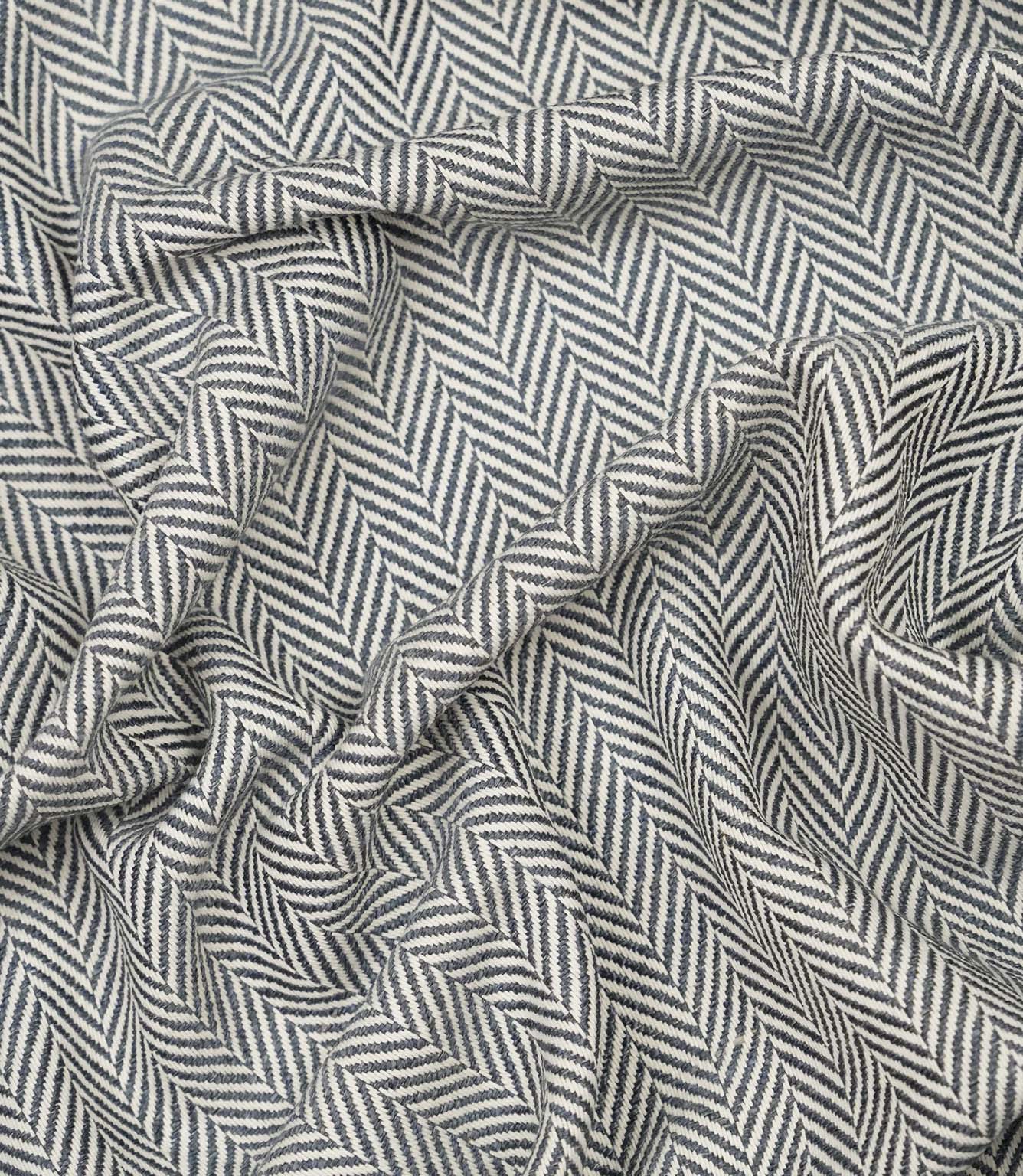 Draped Bampton Ink woven upholstery fabric displaying its soft drape, textured herringbone weave and striking ink blue and ivory chevron pattern.