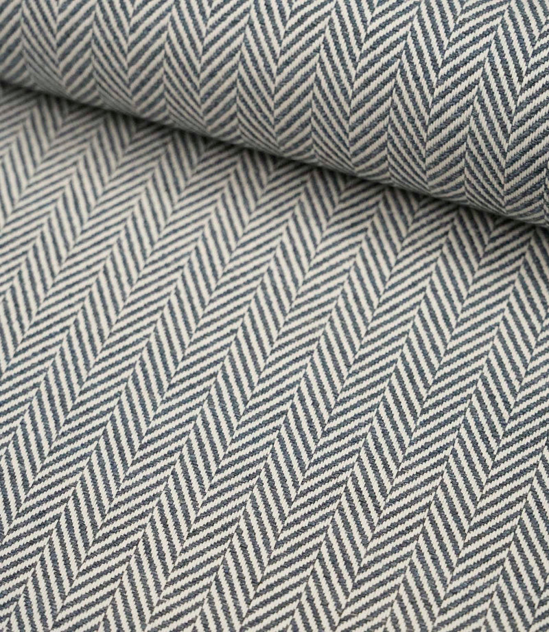 Rolled Bampton Ink upholstery fabric showcasing the woven herringbone chevron pattern in ink blue and ivory, perfect for curtains, blinds and upholstery projects.