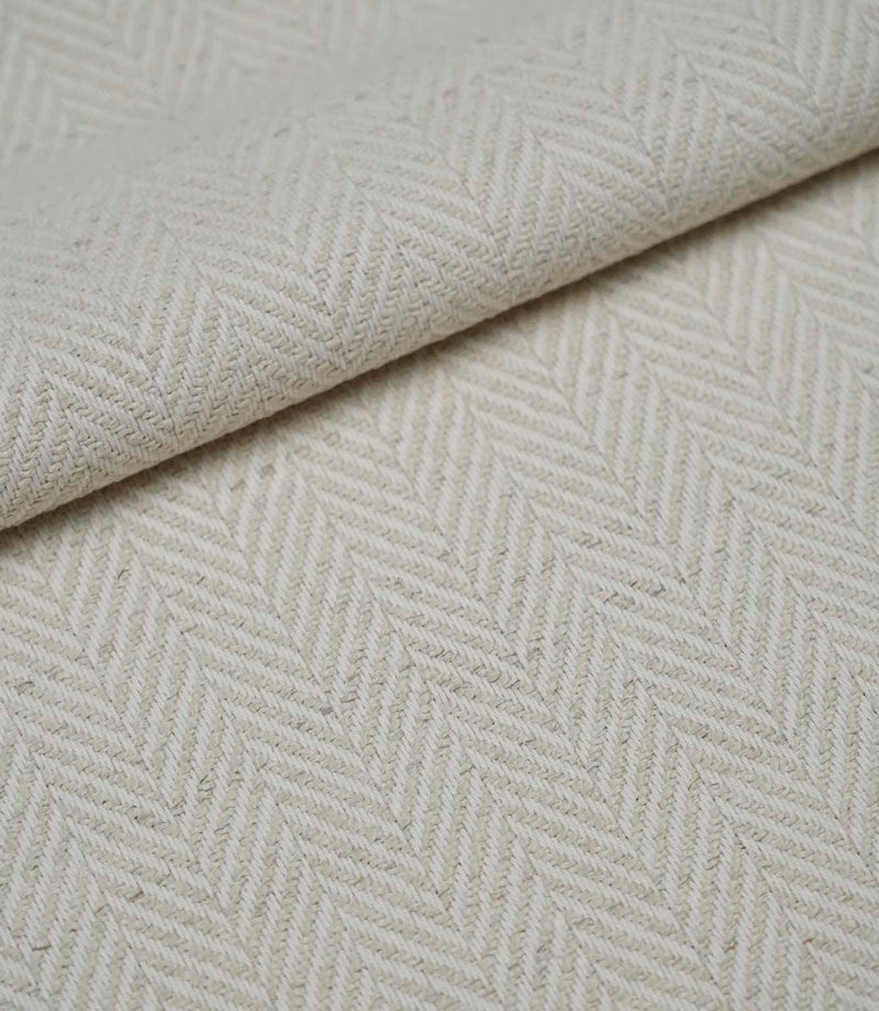 Folded Bampton Jasmine woven fabric showing its soft texture and classic herringbone design.