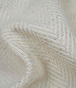 Close-up detail of Bampton Jasmine upholstery fabric showing the woven herringbone texture and fabric weight.