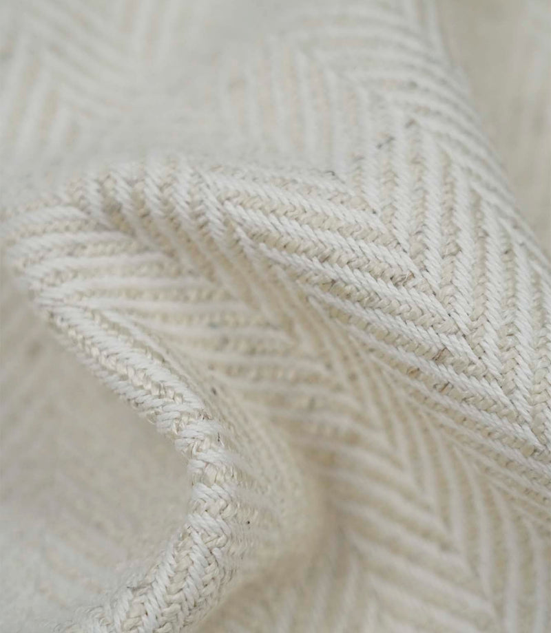 Close-up detail of Bampton Jasmine upholstery fabric showing the woven herringbone texture and fabric weight.