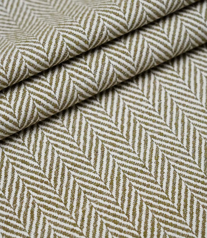 Layered folds of Bampton Matcha upholstery fabric displaying the textured woven herringbone pattern and fabric depth.
