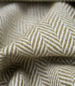 Close-up detail of Bampton Matcha upholstery fabric showing the woven herringbone texture, fabric weight and construction.