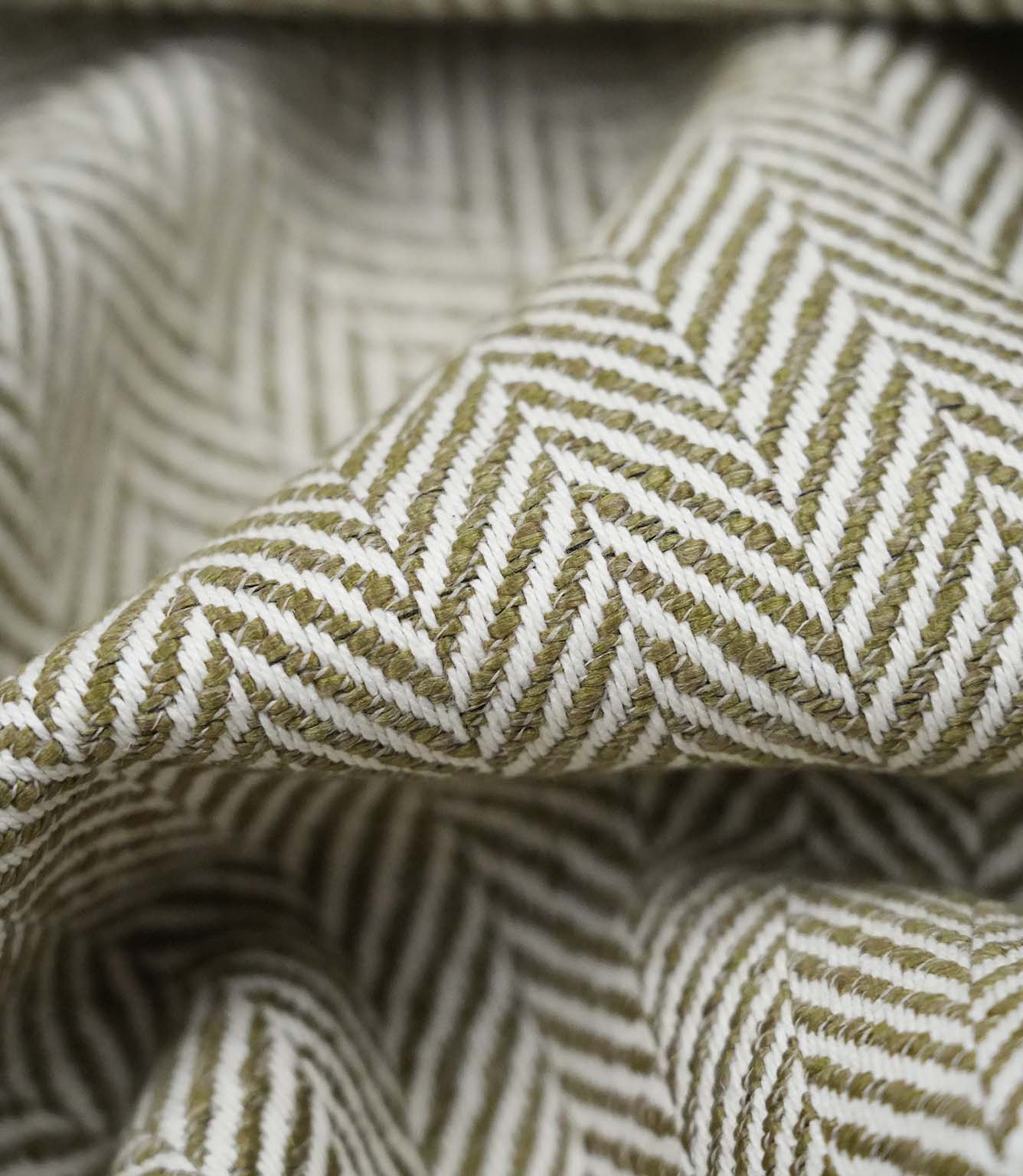 Close-up detail of Bampton Matcha upholstery fabric showing the woven herringbone texture, fabric weight and construction.