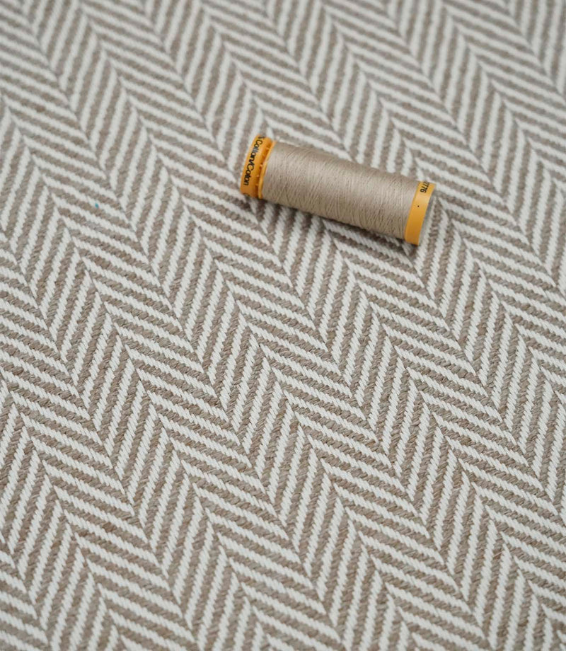 Bampton Taupe woven herringbone upholstery fabric with matching taupe sewing thread, highlighting the textured chevron weave for upholstery and soft furnishing projects.