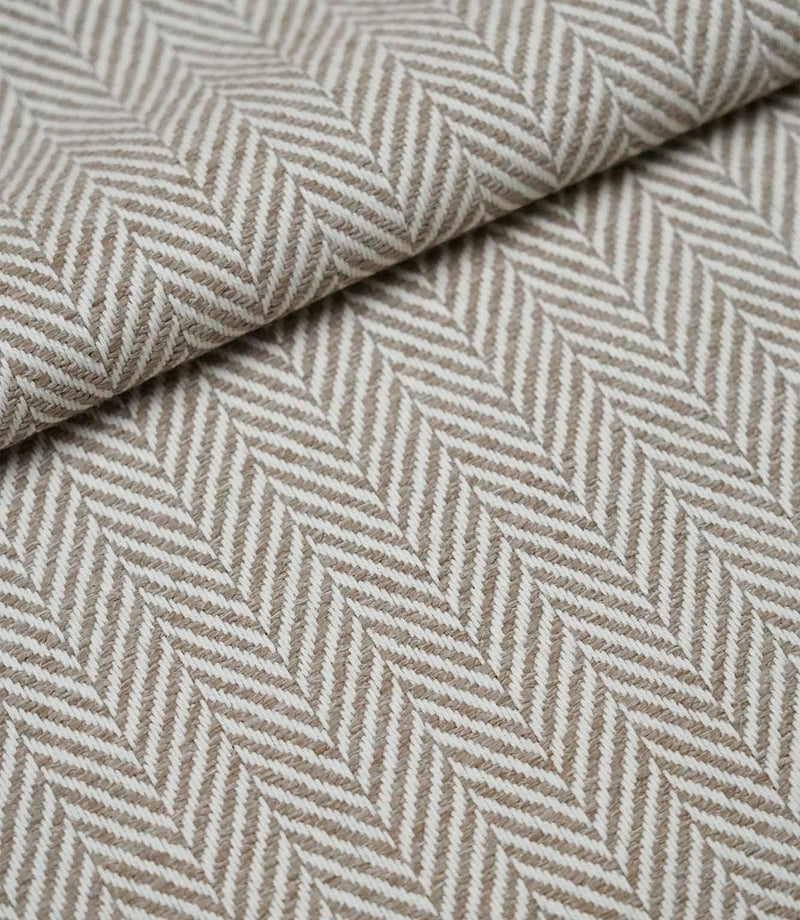 Folded Bampton Taupe upholstery fabric displaying the woven herringbone chevron pattern and durable textured finish, perfect for curtains and upholstery.