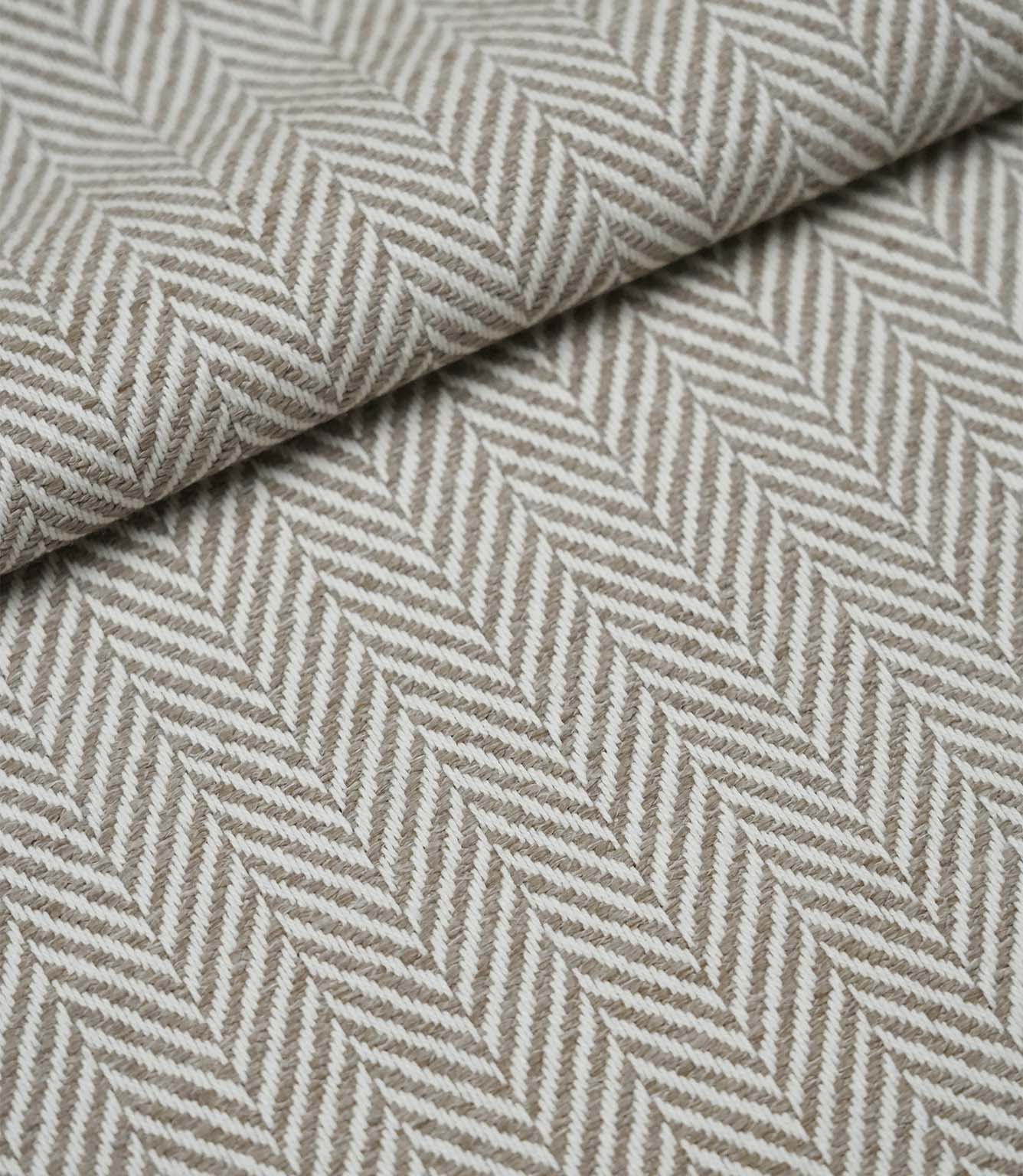 Folded Bampton Taupe upholstery fabric displaying the woven herringbone chevron pattern and durable textured finish, perfect for curtains and upholstery.
