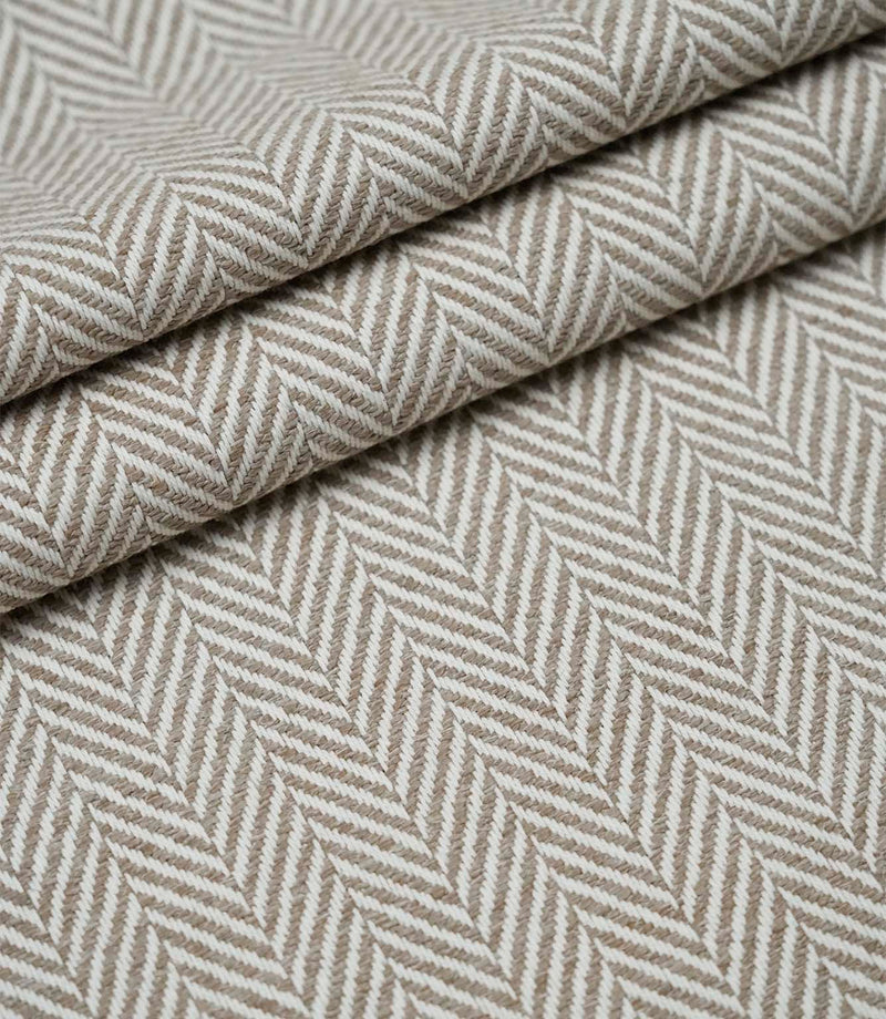 Layered Bampton Taupe woven fabric featuring a subtle chevron herringbone design in warm taupe and ivory, suitable for upholstery and home décor projects.