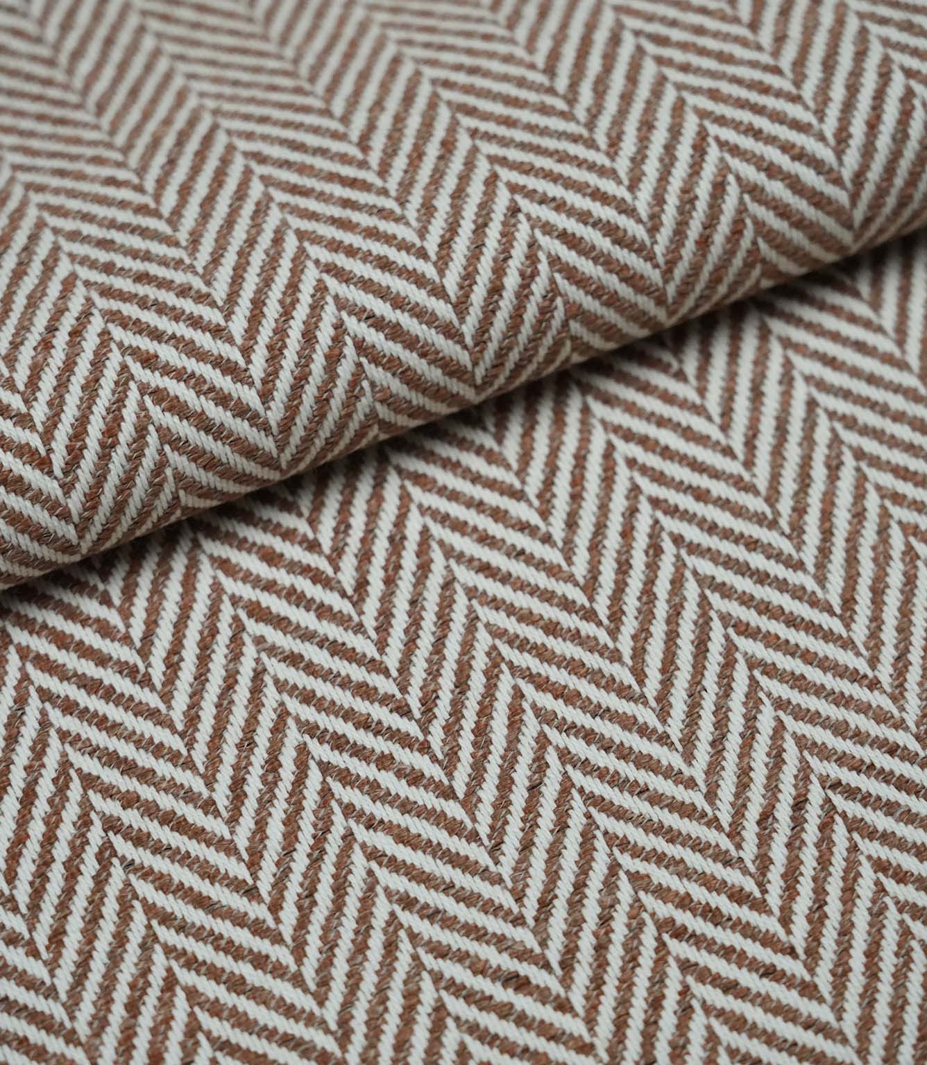 Folded Bampton Terracotta woven herringbone fabric showcasing its textured chevron weave, soft handle and durable upholstery weight for interior furnishing projects.