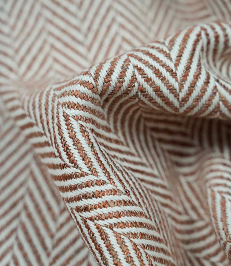 Close-up macro view of Bampton Terracotta woven upholstery fabric highlighting the intricate herringbone chevron weave, textured finish and premium quality construction.