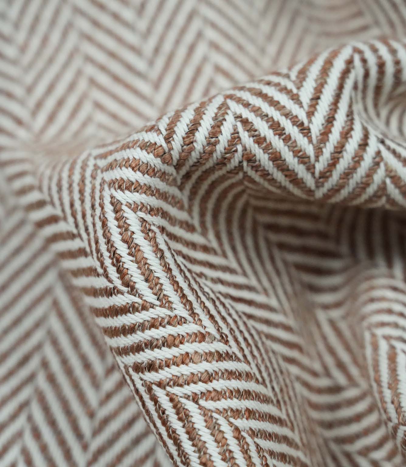 Close-up macro view of Bampton Terracotta woven upholstery fabric highlighting the intricate herringbone chevron weave, textured finish and premium quality construction.