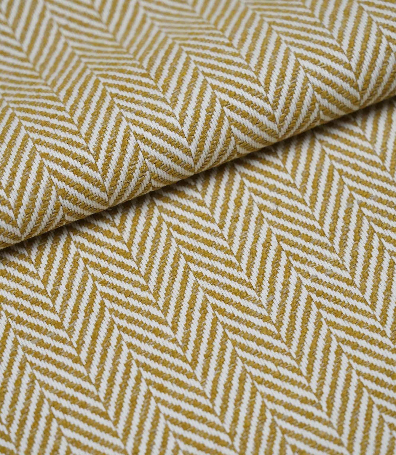 Folded Bampton Turmeric woven herringbone fabric showing the soft texture, fabric weight and classic chevron design.