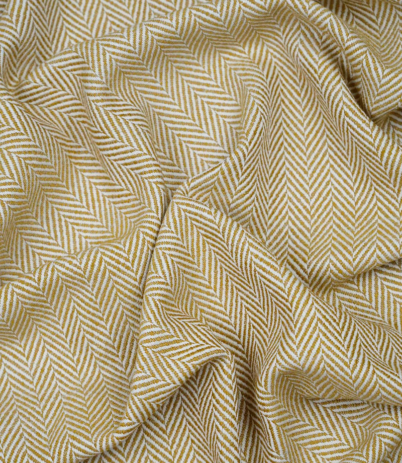 Draped Bampton Turmeric woven herringbone fabric demonstrating its soft handle and elegant drape, ideal for curtains, blinds and cushions.