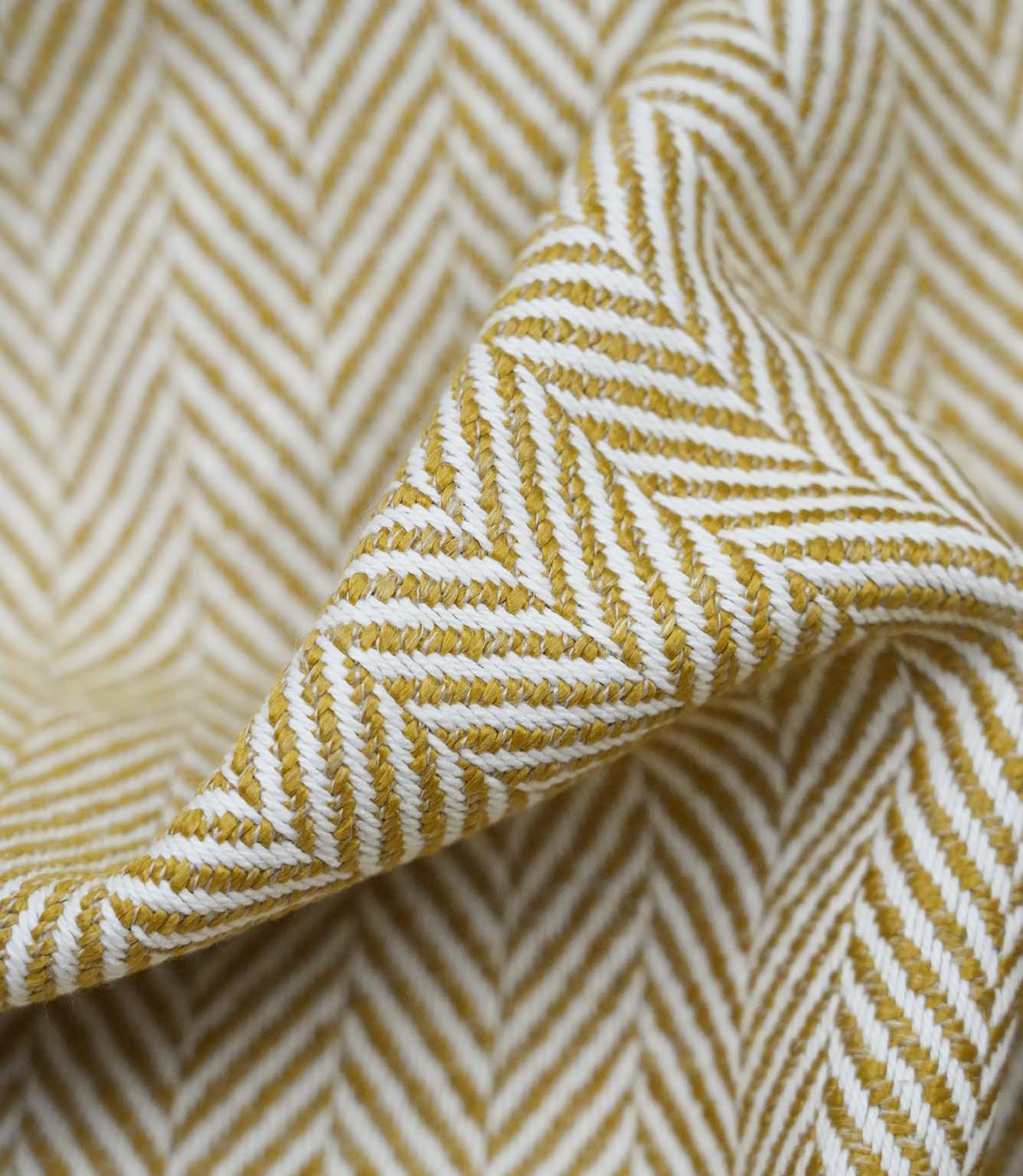 Close-up detail of Bampton Turmeric upholstery fabric highlighting the woven herringbone texture, fabric construction and premium finish.
