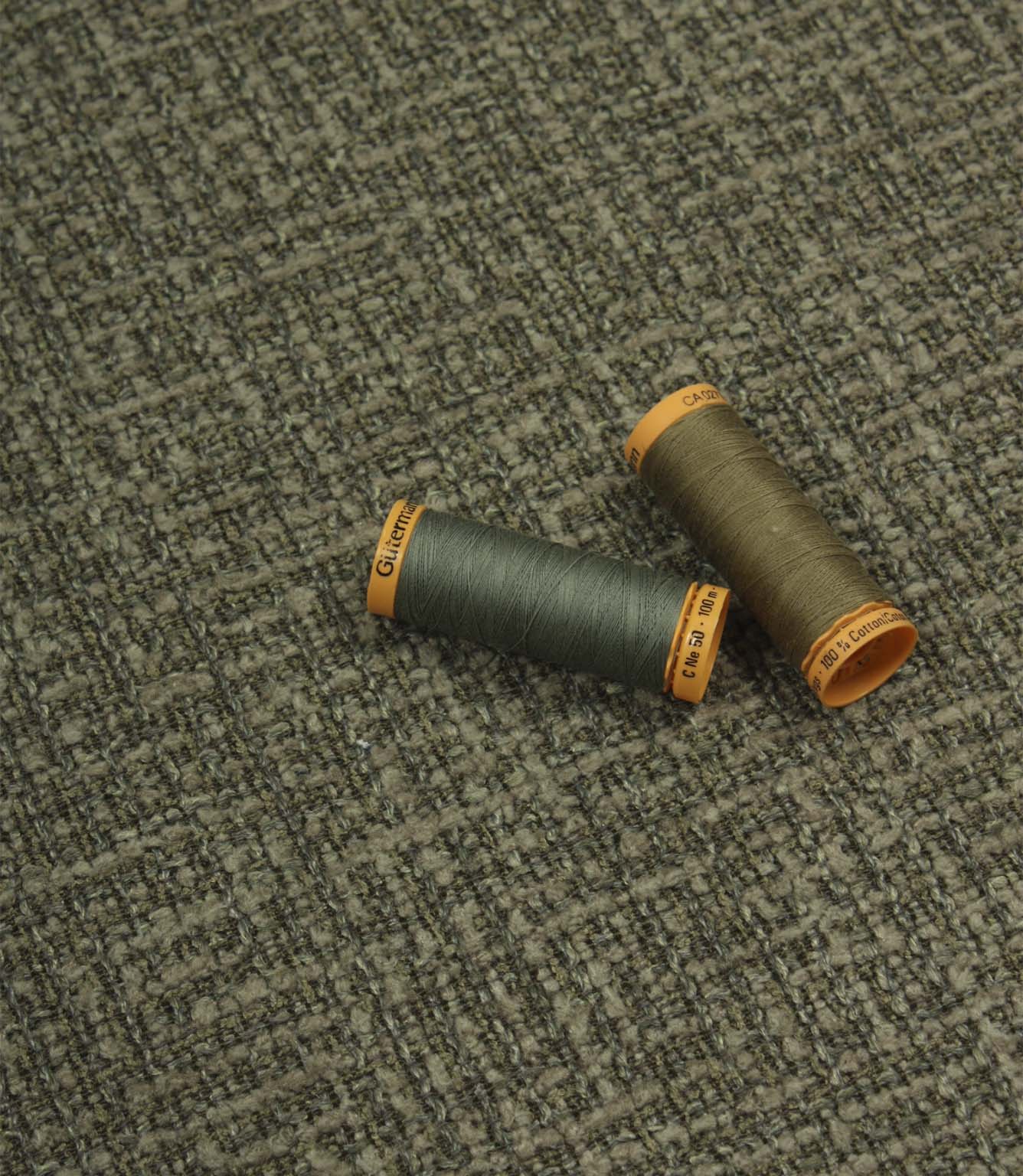 Bellmere Forest upholstery fire retardant fabric displayed with coordinating green and taupe sewing threads.