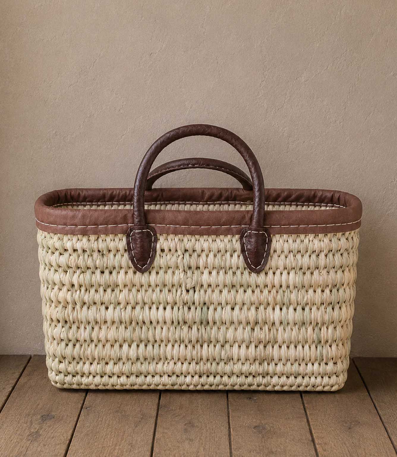 Woven basket tote bag with brown leather trim and handles