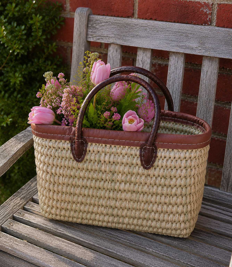 Woven basket tote bag with brown leather trim and handles
