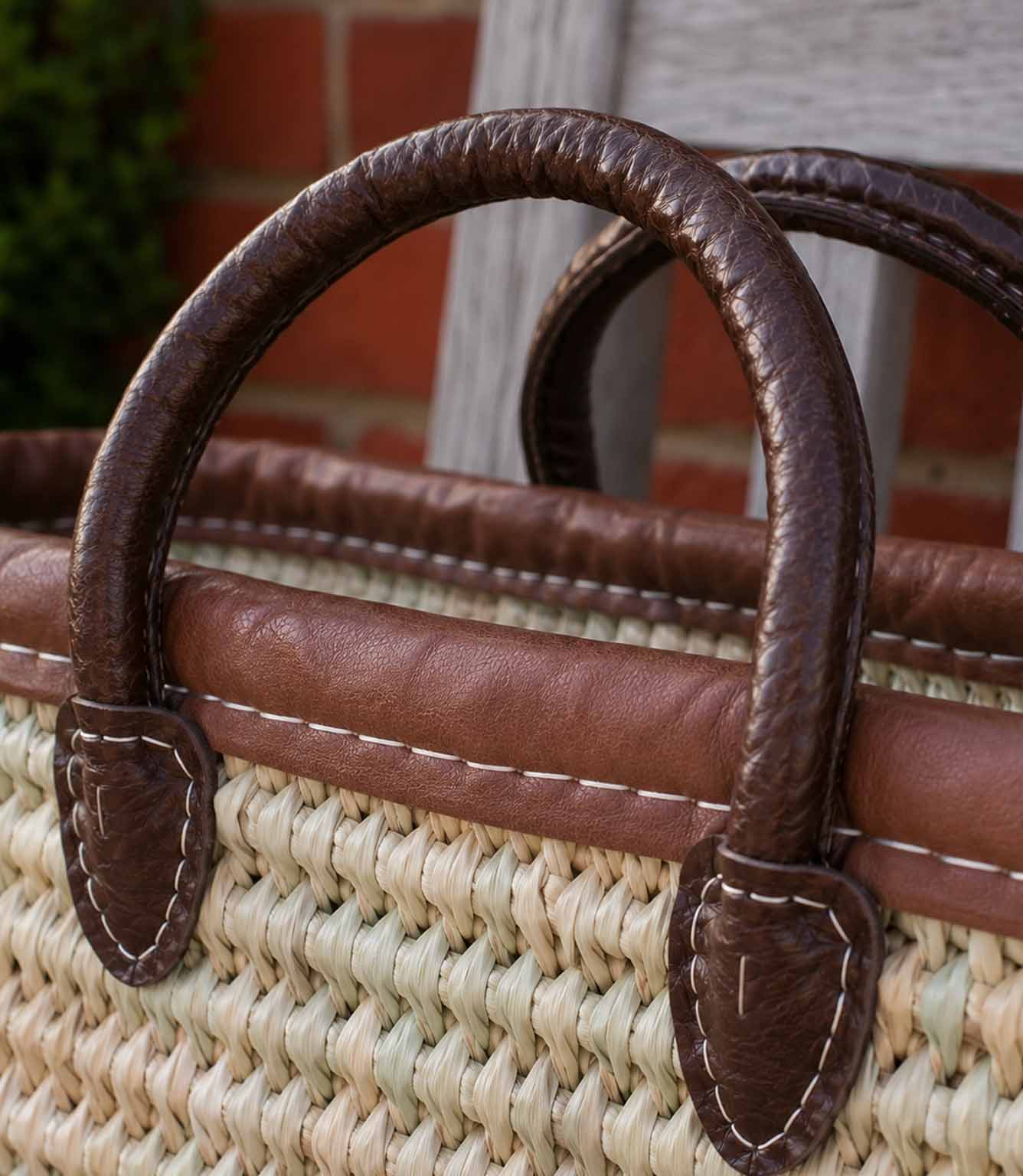 Woven basket tote bag with brown leather trim and handles