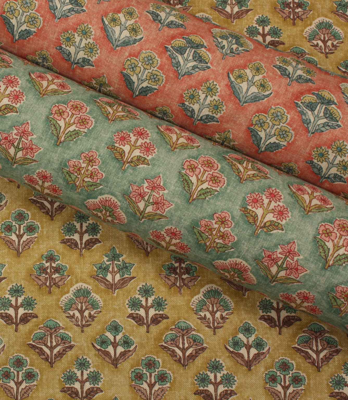 Three colourways of Boho Blossom floral fabric displayed together in mustard yellow, sage green and terracotta tones.