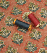 Boho Blossom floral fabric with coordinating navy and coral thread spools displayed on the terracotta ditsy floral pattern.