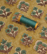 Boho Blossom floral fabric with coordinating teal thread spool displayed on the patterned mustard yellow fabric.