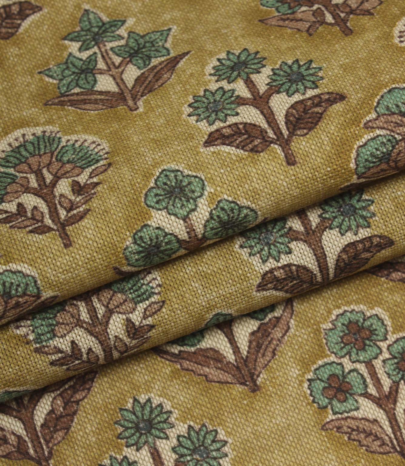 Folded Boho Blossom ditsy floral fabric highlighting the warm mustard background and teal botanical print.