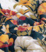 Close-up of the Bootanical Sherpa fleece throw showing the soft plush texture and detailed dark teal, orange, red, cream and green autumn floral and pumpkin pattern.