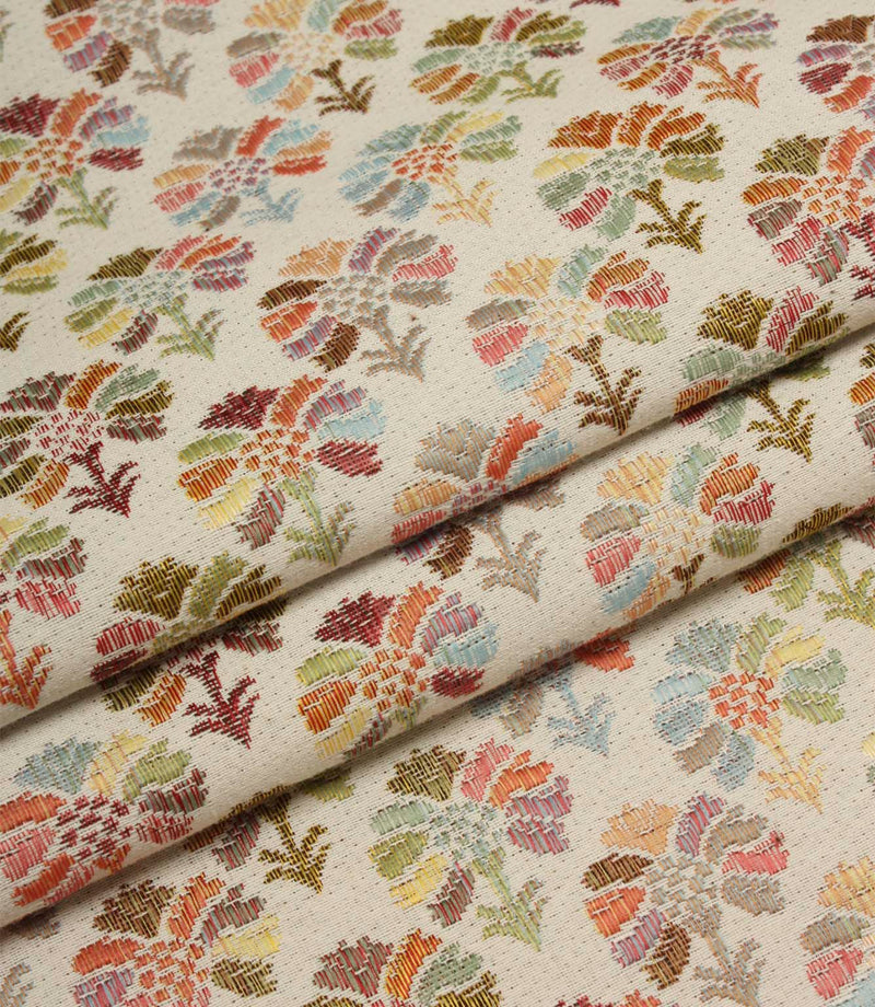 Folded Briar Sprig Jasmine woven fabric highlighting the detailed floral and foliage pattern in soft pink, sage, blue, terracotta and mustard shades.