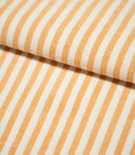 Close-up of Broadway Stripe Sunflower fabric folded over itself, highlighting the crisp alternating orange and off-white stripes, consistent stripe spacing and tactile woven surface as the pattern curves naturally around the fold.