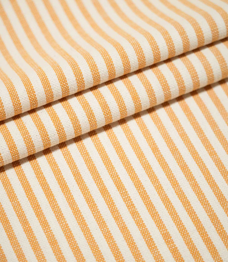 Broadway Stripe Sunflower fabric arranged in three neat overlapping folds, displaying the repeating sunflower orange and off-white striped design and textured weave across both flat and gently curved surfaces.