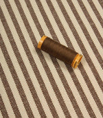 Broadway Stripe Mocha striped upholstery fabric with coordinating brown thread, highlighting the timeless vertical stripe design and woven texture.