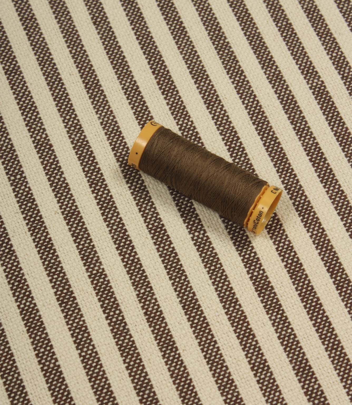 Broadway Stripe Mocha striped upholstery fabric with coordinating brown thread, highlighting the timeless vertical stripe design and woven texture.