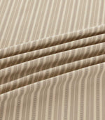 Close-up of Brookhaven Gull striped fabric in soft flowing folds, displaying neutral taupe and cream stripes with subtle dotted detailing and woven texture.
