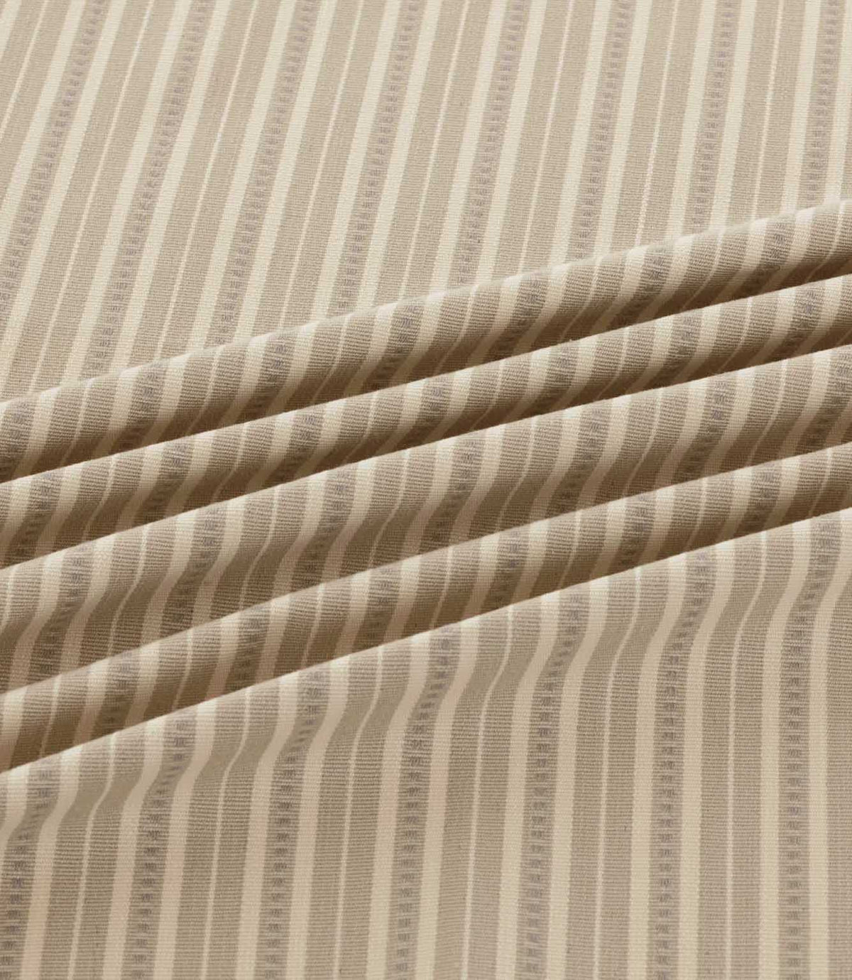 Close-up of Brookhaven Gull striped fabric in soft flowing folds, displaying neutral taupe and cream stripes with subtle dotted detailing and woven texture.
